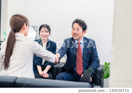 Three smiling business people shaking hands Three smiling business people shaking hands 130538733