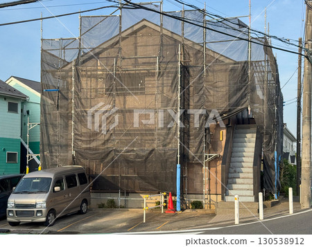 用於粉刷公寓大樓外牆的鷹架和黑色網 130538912