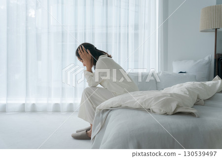 一名身穿睡衣、身體不適的女子 一名身穿睡衣、身體不適的女子 130539497