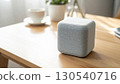 Modern Gray Smart Speaker on Wooden Table with White Cup in Bright Minimalist Interior 130540716