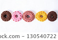 Five Colorful Donuts with Chocolate Sprinkles on White Background in Bright Studio Lighting 130540722