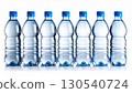 Seven Blue Capped Plastic Water Bottles Lined Up Against a White Background in Studio Lighting 130540724
