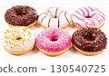 Assorted Doughnuts Featuring Chocolate Pink and White Frosting Isolated in Studio 130540725