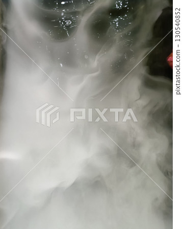 Swirling mixture of white and gray smoke or vapor creating abstract pattern, with hints of dark background and subtle reflections, evoking Swirling mixture of white and gray smoke or vapor creating abstract pattern, with hints of dark background and subtle reflections, evoking 130540852