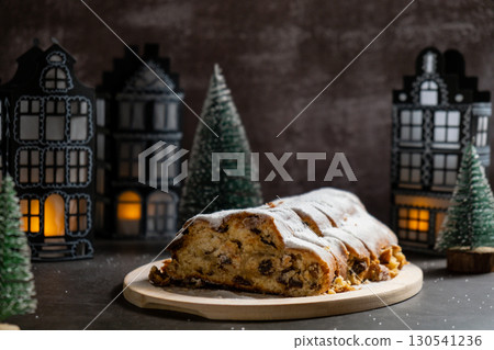 Homemade Christmas traditional cake pie with marzipan nuts and dried fruits pastry dessert stollen. Winter holidays season atmosphere. Delicious tasty composition home table setting Homemade Christmas traditional cake pie with marzipan nuts and dried fruits pastry dessert stollen. Winter holidays season atmosphere. Delicious tasty composition home table setting 130541236