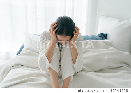 A woman in pajamas who is unwell A woman in pajamas who is unwell 130541308