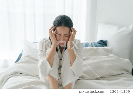 A woman in pajamas who is unwell A woman in pajamas who is unwell 130541309
