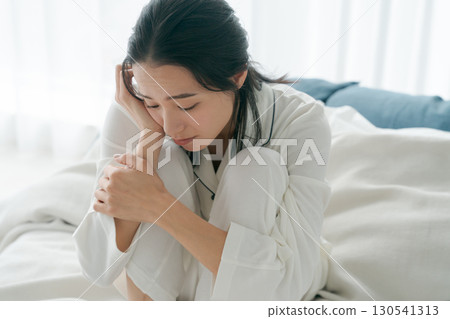 一名身穿睡衣、身體不適的女子 一名身穿睡衣、身體不適的女子 130541313