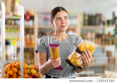 Woman choosing pasta and spaghetti Woman choosing pasta and spaghetti 130541588