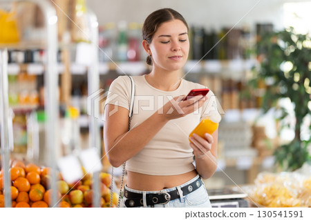 Young woman scanning qr code for yellow smoothie Young woman scanning qr code for yellow smoothie 130541591