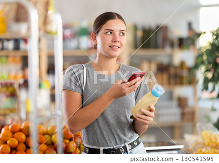 Young woman scanning qr code for mayonnaise Young woman scanning qr code for mayonnaise 130541595