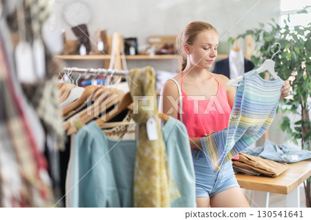 Teenage girl choosing something for summer in clothing store Teenage girl choosing something for summer in clothing store 130541641