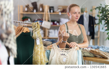 Teenage girl choosing summer clothes in store 130541665