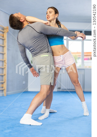 Self-defense training - woman practicing blows to the head of male attacker Self-defense training - woman practicing blows to the head of male attacker 130542190