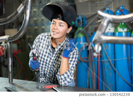 Young woman working with welding machine Young woman working with welding machine 130542239