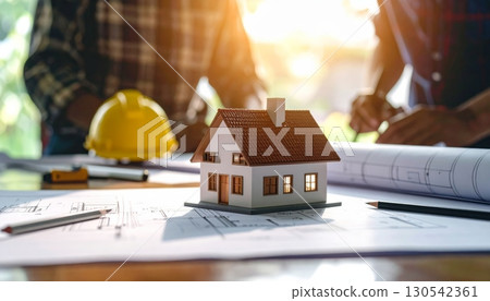Real estate concept: a miniature house and keys rest on a blueprint, representing the structure and business of Real estate concept: a miniature house and keys rest on a blueprint, representing the structure and business of 130542361