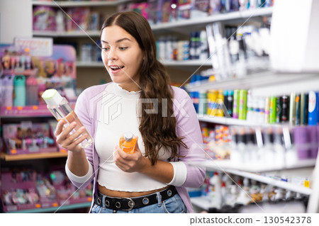 Young woman is choosing new conditioner in hair care store Young woman is choosing new conditioner in hair care store 130542378