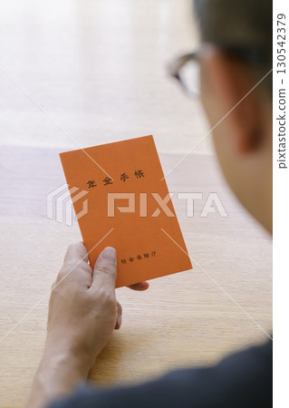A man looking at his pension book 130542379