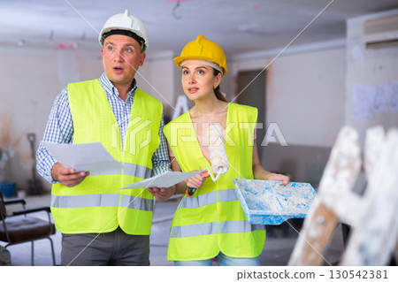 Foreman and woman painter discussing design of room 130542381