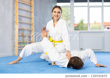 Adult man and young woman training judo fight Adult man and young woman training judo fight 130542655