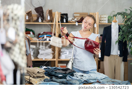 Young teen girl choosing a fashionable handbag in boutique 130542723