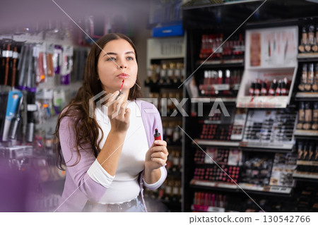 Stylish woman testing new lipstick, shopping in cosmetics store Stylish woman testing new lipstick, shopping in cosmetics store 130542766