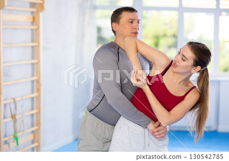 Adult man and young woman training self-defense techniques Adult man and young woman training self-defense techniques 130542785