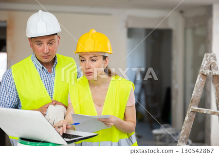 Woman architect and man engineer using laptop in construction site 130542867
