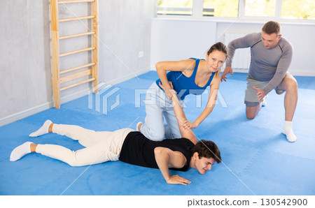 Woman learns to make power grab against male attacker under guidance of trainer. Self-defense class 130542900