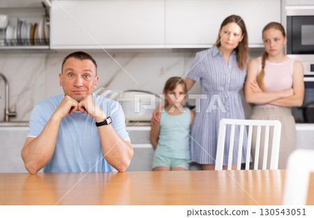 Wife and children stand behind dad and are afraid to ask about current problem 130543051