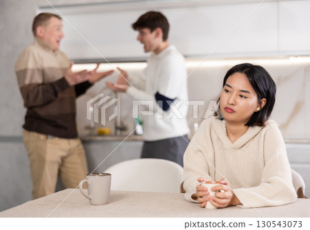 Young girl is tired of domestic quarrels. Relatives quarreling in background Young girl is tired of domestic quarrels. Relatives quarreling in background 130543073