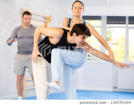 Guy paired up with woman to perform effective impact on pain points while learning self-defense. 130543104