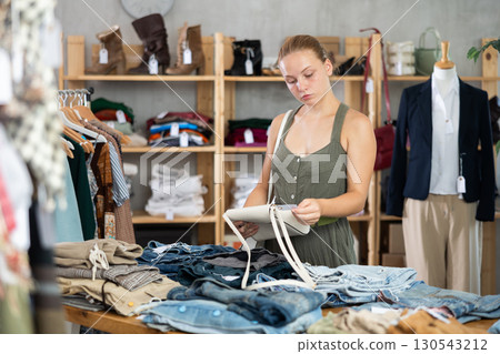 European buyer chooses a handbag in a store 130543212