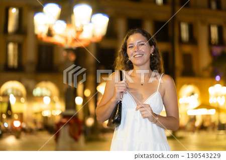 young woman walks along an evening street in Barcelona young woman walks along an evening street in Barcelona 130543229