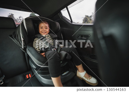 happy toddler girl sitting in car seat, safety baby chair travelling happy toddler girl sitting in car seat, safety baby chair travelling 130544163