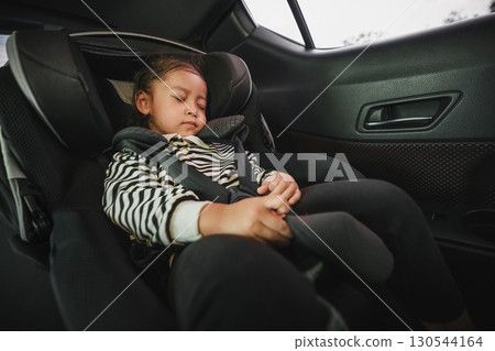 toddler girl sitting and sleeping in car seat, safety baby chair travelling 130544164
