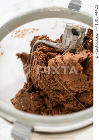 Thick, chocolatey dough formed in the stand mixer for Chocolate Ginger Sugar Cookie Dough, capturing the final texture before shap 130544422