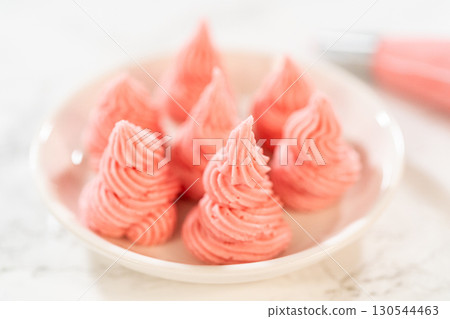 Small plate filled with perfectly piped raspberry buttercream swirls from the Easter Cookie Sandwich with Raspberry Buttercream recipe. Suitable for blog headers or sweet treat visuals. Small plate filled with perfectly piped raspberry buttercream swirls from the Easter Cookie Sandwich with Raspberry Buttercream recipe. Suitable for blog headers or sweet treat visuals. 130544463