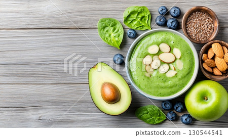 Fresh Healthy Green Smoothie with Spinach, Avocado, Blueberries, and Almonds on Wooden Table 130544541