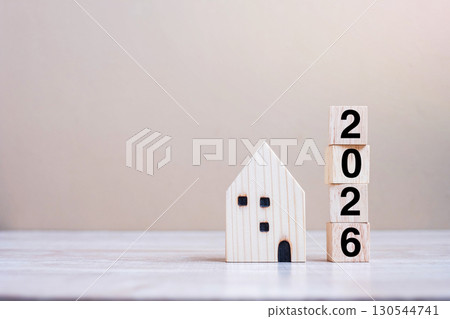 2026 Happy New Year with house model on table wooden background. Banking, real estate, investment, financial, savings and New Year Resolution concepts 130544741