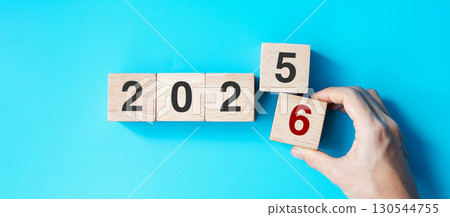 hand holding wooden cube block with 2026 text on blue background. Resolution, plan, review, goal, start and New Year holiday concepts 130544755
