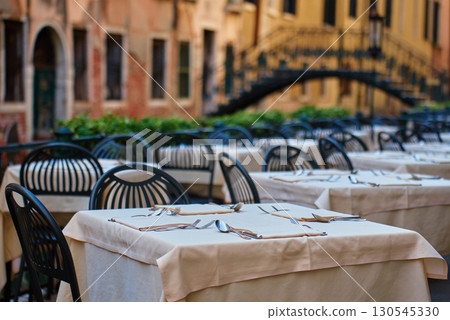 Empty outdoor restaurant tables with cutlery in Venice, Italy Empty outdoor restaurant tables with cutlery in Venice, Italy 130545330