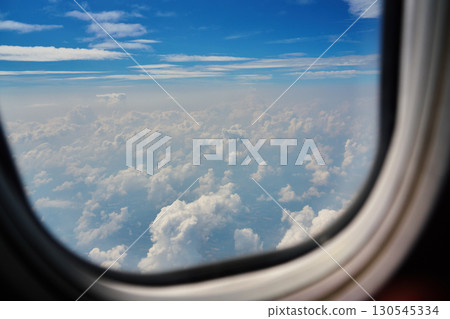 View of clouds through airplane window during flight 130545334