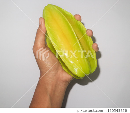 hand holds a carambola. Organic farming rural agriculture  130545856