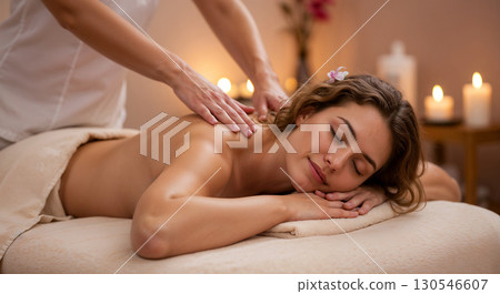 Young woman enjoying a relaxing back massage in a luxury spa. 130546607