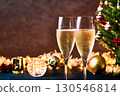 Toasting with champagne glasses in front of the Christmas tree and illuminations 130546814