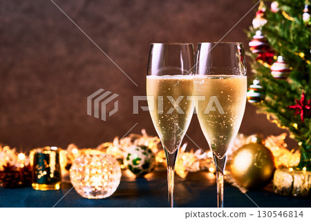 Toasting with champagne glasses in front of the Christmas tree and illuminations Toasting with champagne glasses in front of the Christmas tree and illuminations 130546814