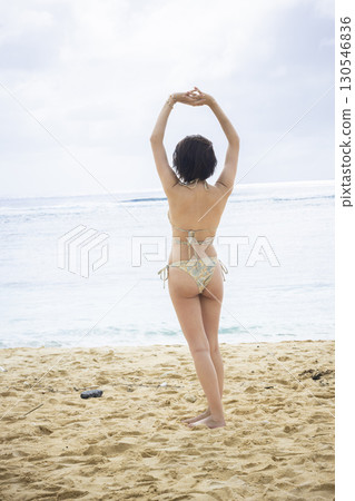 Young woman in a swimsuit looking at the sea 130546836