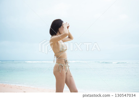 穿著泳衣看海的年輕女子 130547034