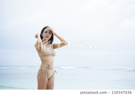 穿著泳衣看海的年輕女子 130547036